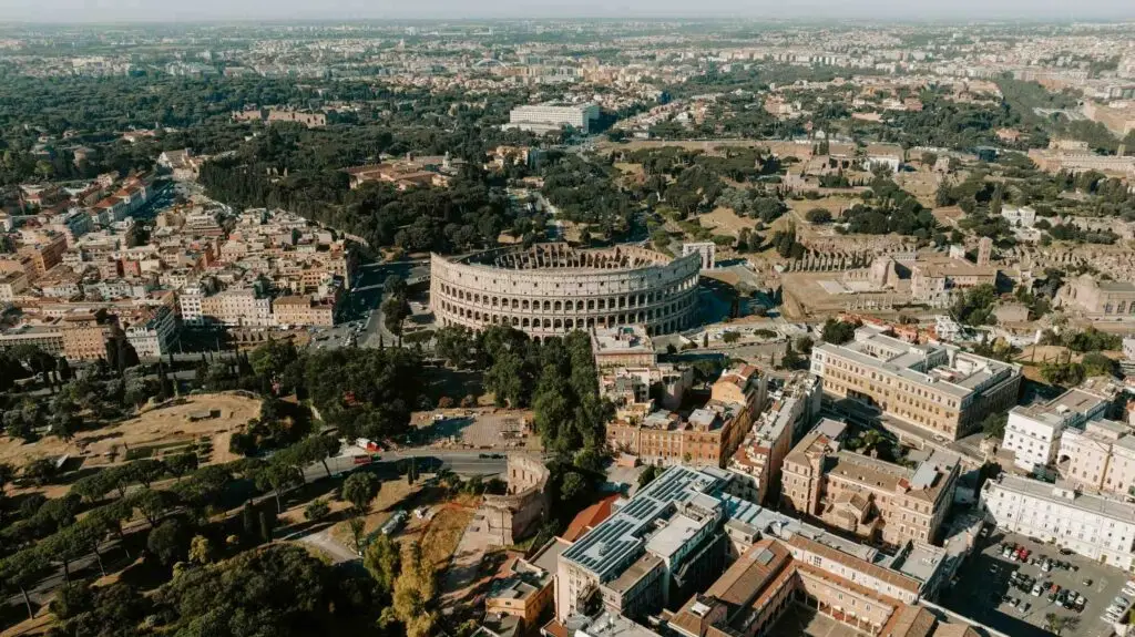 Aerial view of Colosseum and surrounding cityscape.