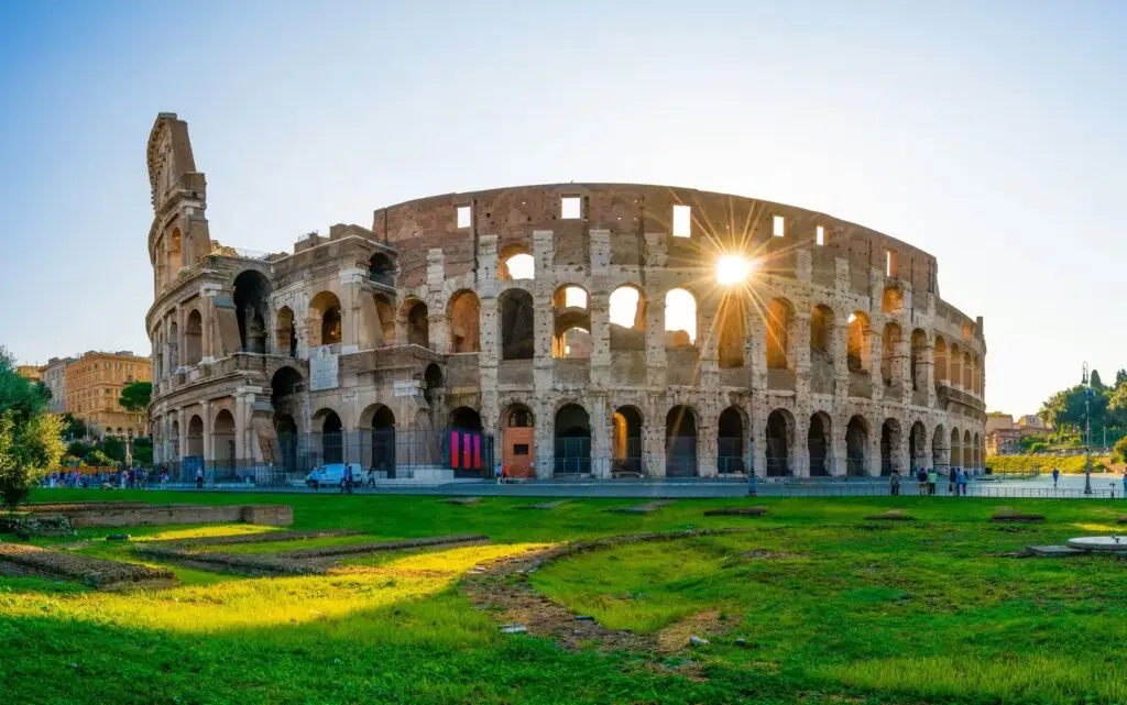 The Colosseum in Rome at sunset with sun rays.